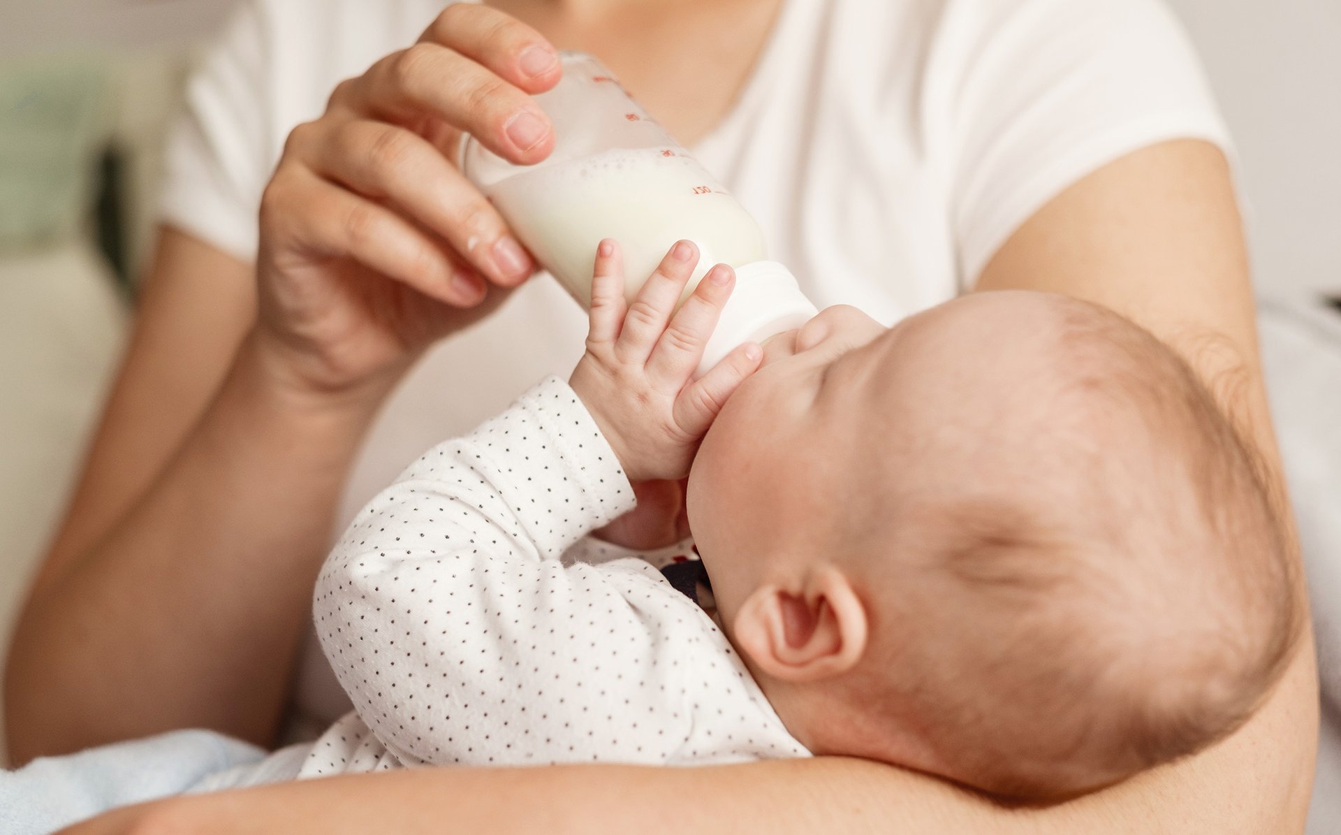 Mama karmi dziecko mlekiem modyfikowanym z butelki