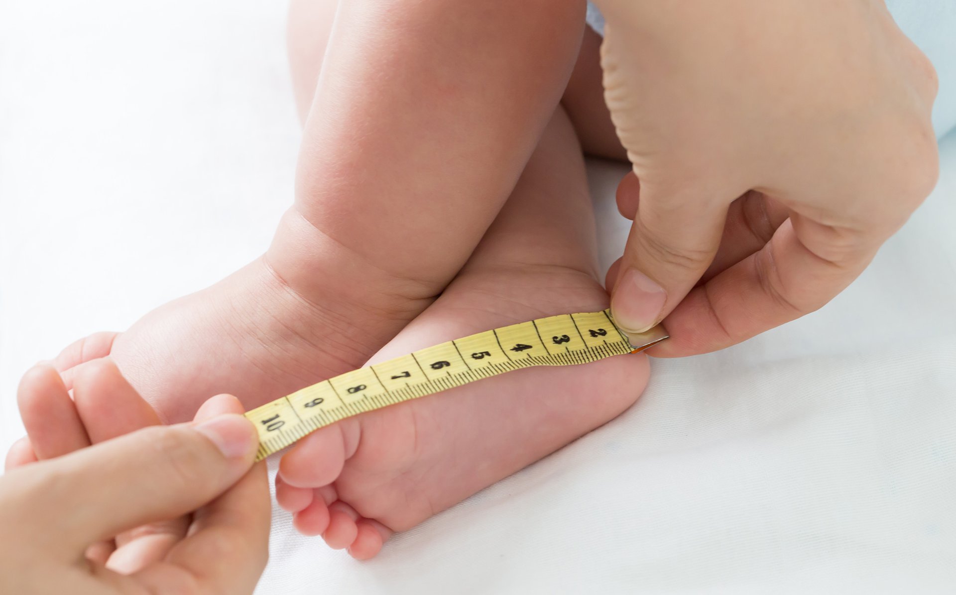Kobieta mierzy miarka stope dziecka