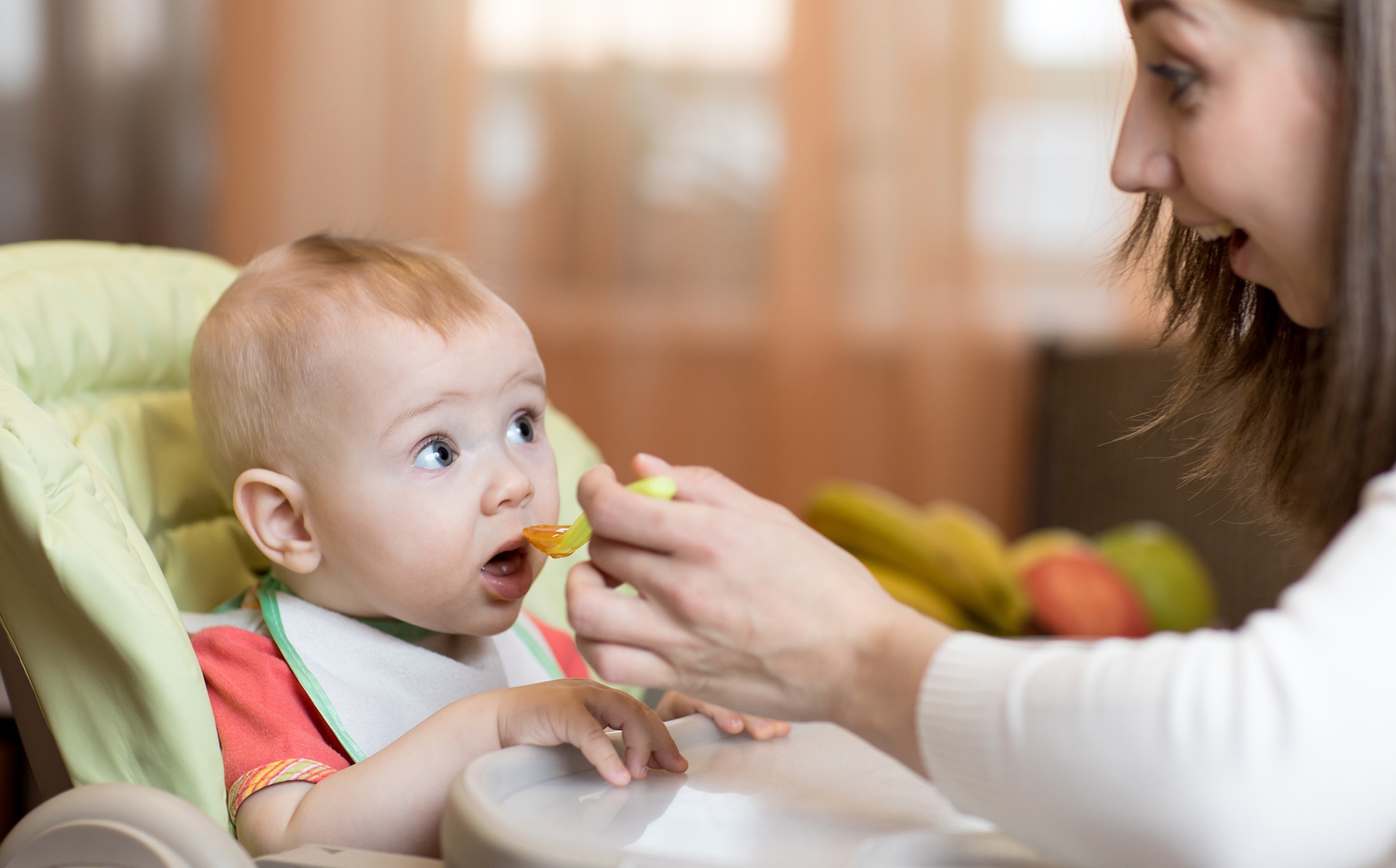 Dziecko patrzy na mame jedzac pokarm z lyzeczki