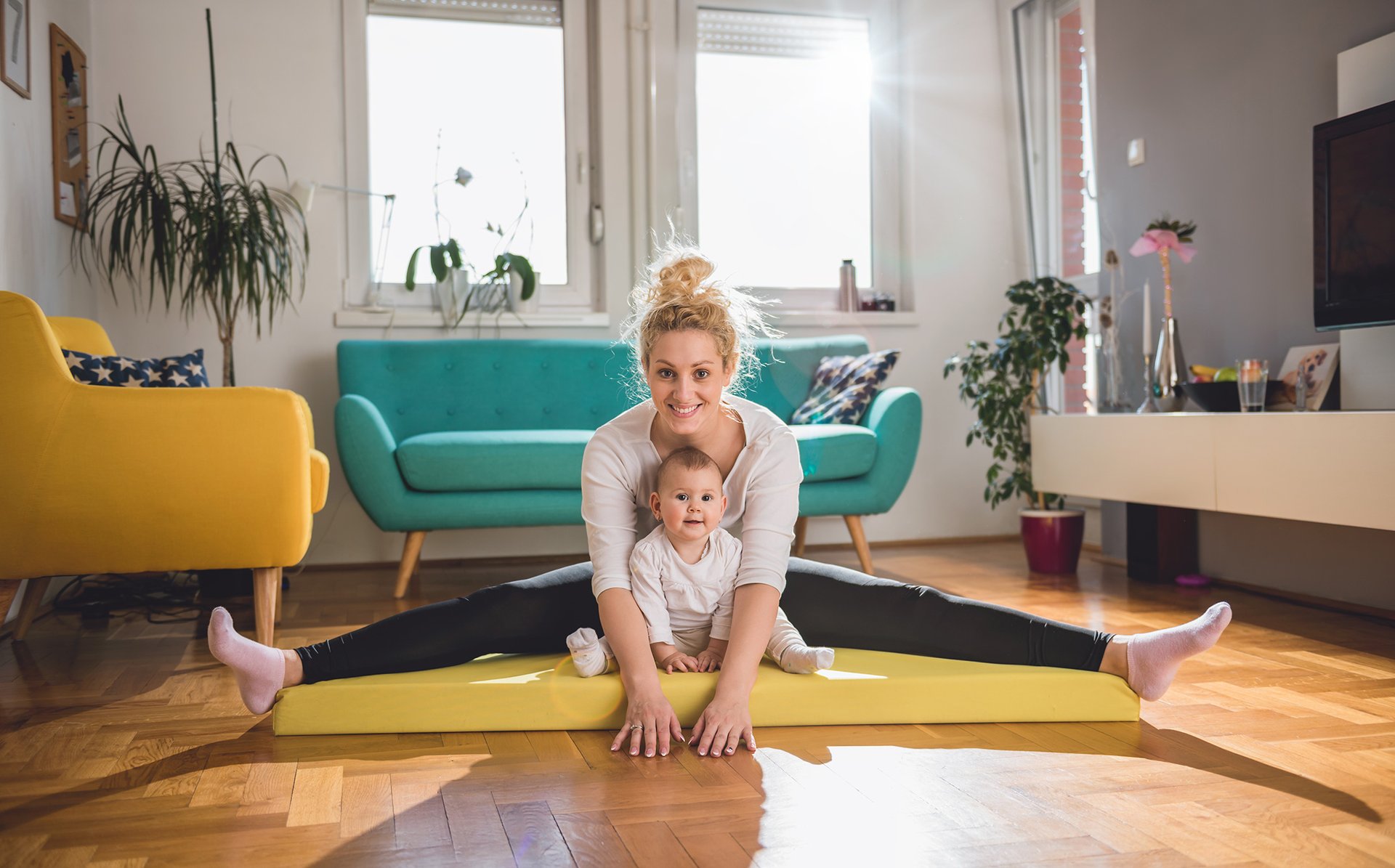 Mama cwiczy z dzieckiem na macie do jogi